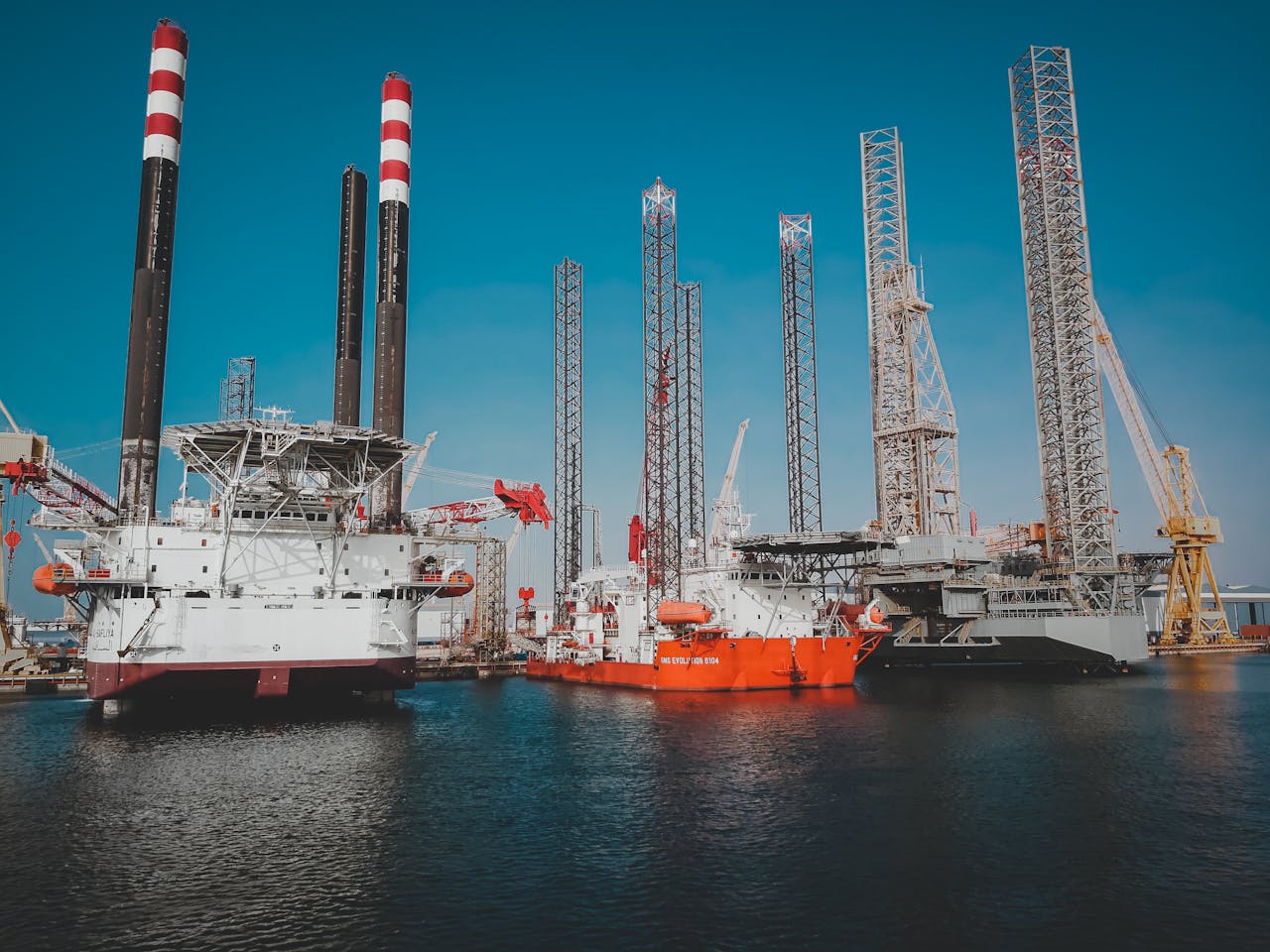 High angle view of offshore oil platforms in Ras Laffan, Qatar under clear blue sky.